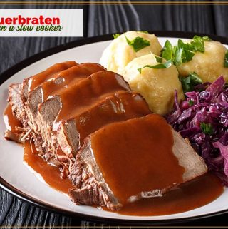 sliced sauerbraten on a plate with gravy, potatoes and red cabbage