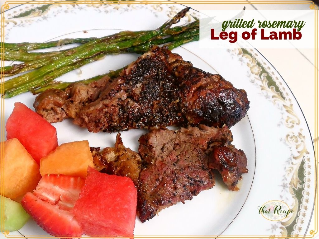 slices of grilled leg of lamb on a plate with asparagus and fresh fruit
