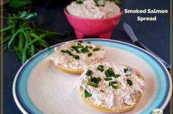 smoked salmon spread on a bagel with a bowl of smoked salmon spread in a pink bowl.