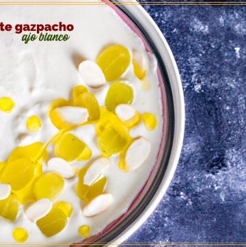 white soup topped with grapes and olive oil in a bowl with text overlay "white gazpacho ajo blanco"