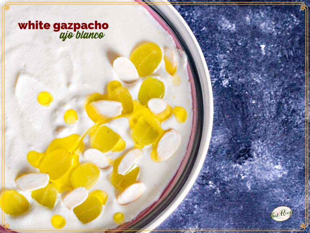 white soup topped with grapes and olive oil in a bowl with text overlay "white gazpacho ajo blanco"