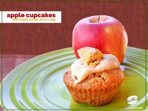 Cupcake on a plate with an apple and text overlay "Apple Cupcakes with Maple Cream Cheese Icing"