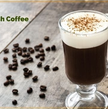 glass mug of Irish Coffee surrounded by coffee beans