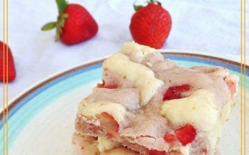 cookie bars on a plate with fresh strawberries in the background with text overlay "Fresh Strawberry Cream Cheese Swirl Bars"