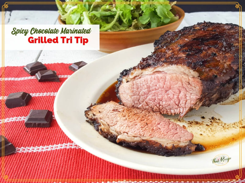 tri tip roast on a plate with a salad and chocolate pieces and text overlay "Spiced Chocolate Marinated Grilled Tri Tip"