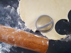 rolled out pastry dough with rolling pin and biscuit cutter