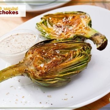 artichoke halves on a plate with dipping sauce ad text overlay "herb roasted artichokes"