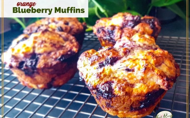 jumbo muffins on a cooling rack with text overlay "orange blueberry muffins"