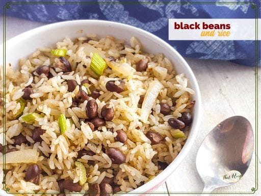 bowl of black beans and rice on white wood background with blue cloth