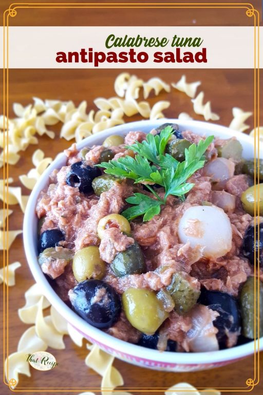 bowl of antipasto salad on a table surrounded by pasta with text overlay "Calabrese tuna Antipasto Salad"