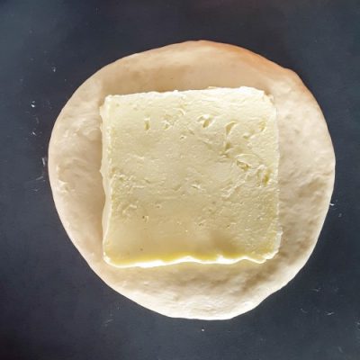 square of butter on circle of dough