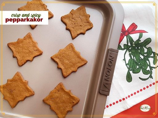 cut out cookies on a baking tray with text overlay "sweet and spicy Pepparkakor"
