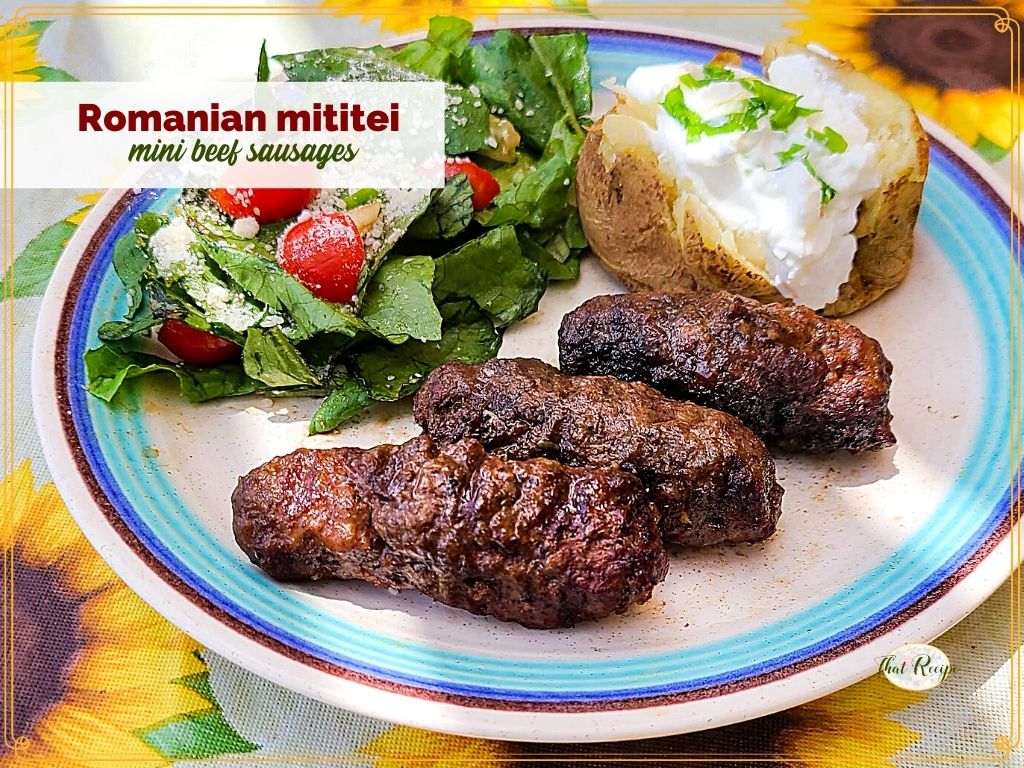 mini sausages on a plate with salad and potato and text overlay "Romanian mititei mini beef sausages"