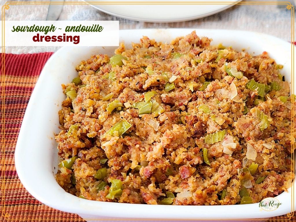 stuffing in a casserole dish with text overlay "sourdough andouille dressing"