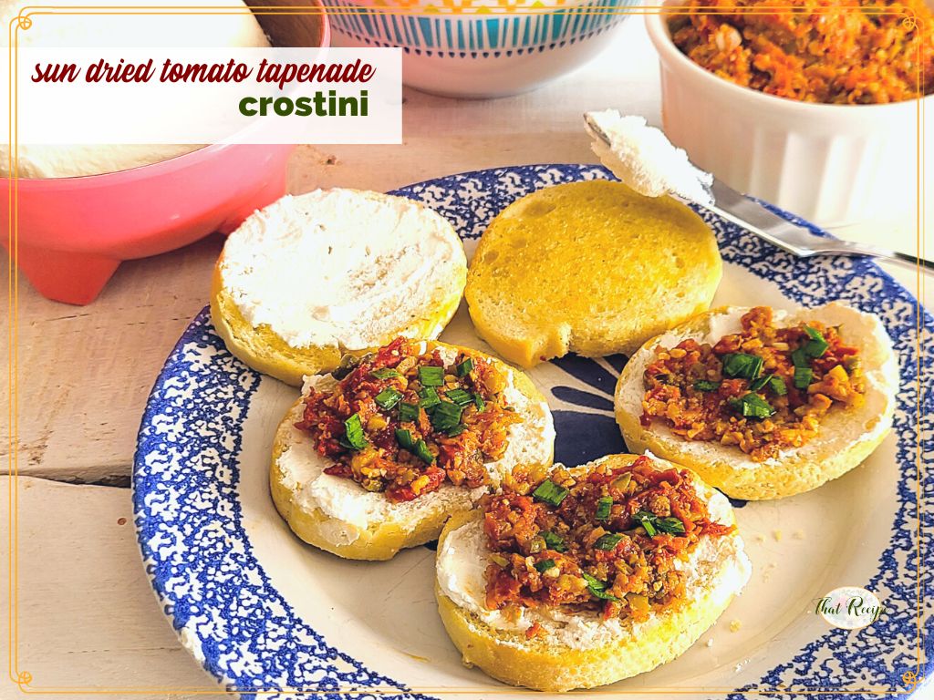 crostini on a plate with text overlay "sun dried tomato tapenade crostini"