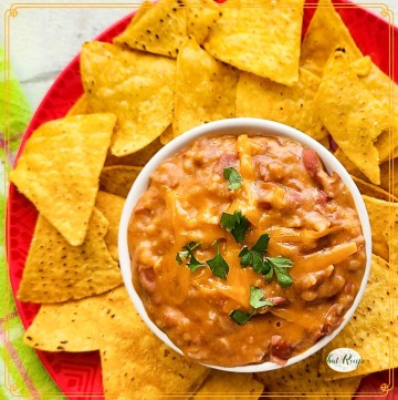 chili dip on a plate with chips and text overlay "beef and bean chili dip"