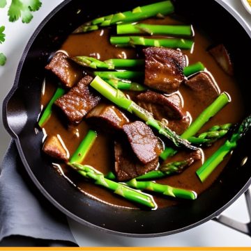 beef tips and asparagus in dark sauce in a skillet