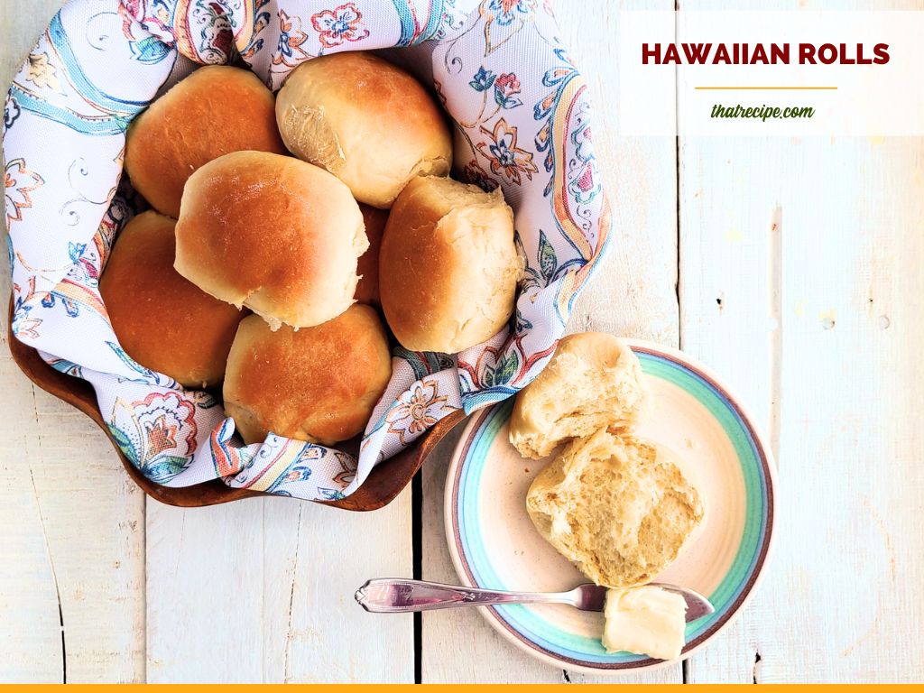 hawaiian rolls in a bowl next to opened roll on a plate with butter