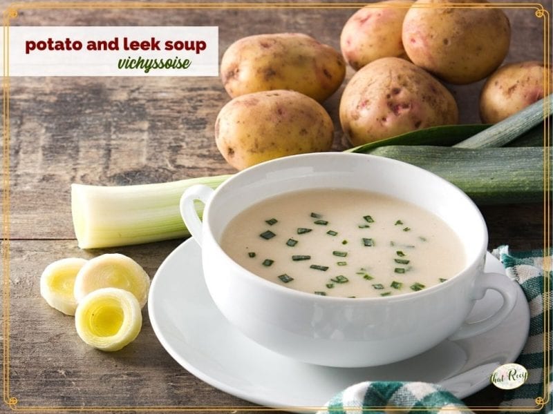 potato soup in a bowl surrounded by potatoes and leeks and text overlay "vichyssoise potato and leek soup"