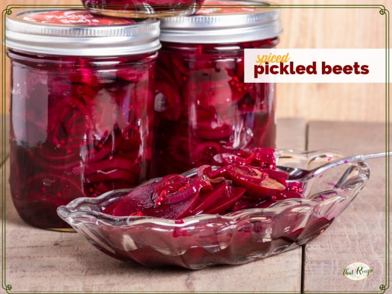 jars of pickled beets with a bowl of beets in front and text overlay "spiced pickled beets"