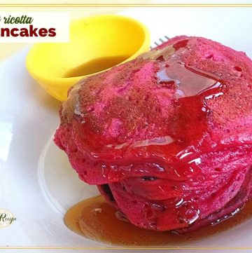 stack of pink pancakes on a plate with maple syrup and text overlay "beet ricotta pancakes"