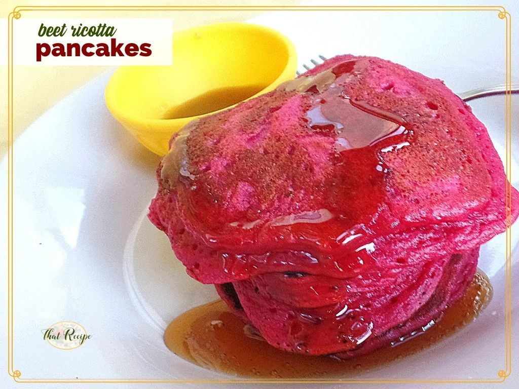 stack of pink pancakes on a plate with maple syrup and text overlay "beet ricotta pancakes"