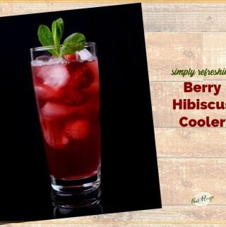 glass of hibiscus tea with raspberries and text overlay "Berry Hibiscus Cooler"