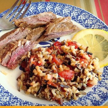 rice pilaf on a plate with steak slices