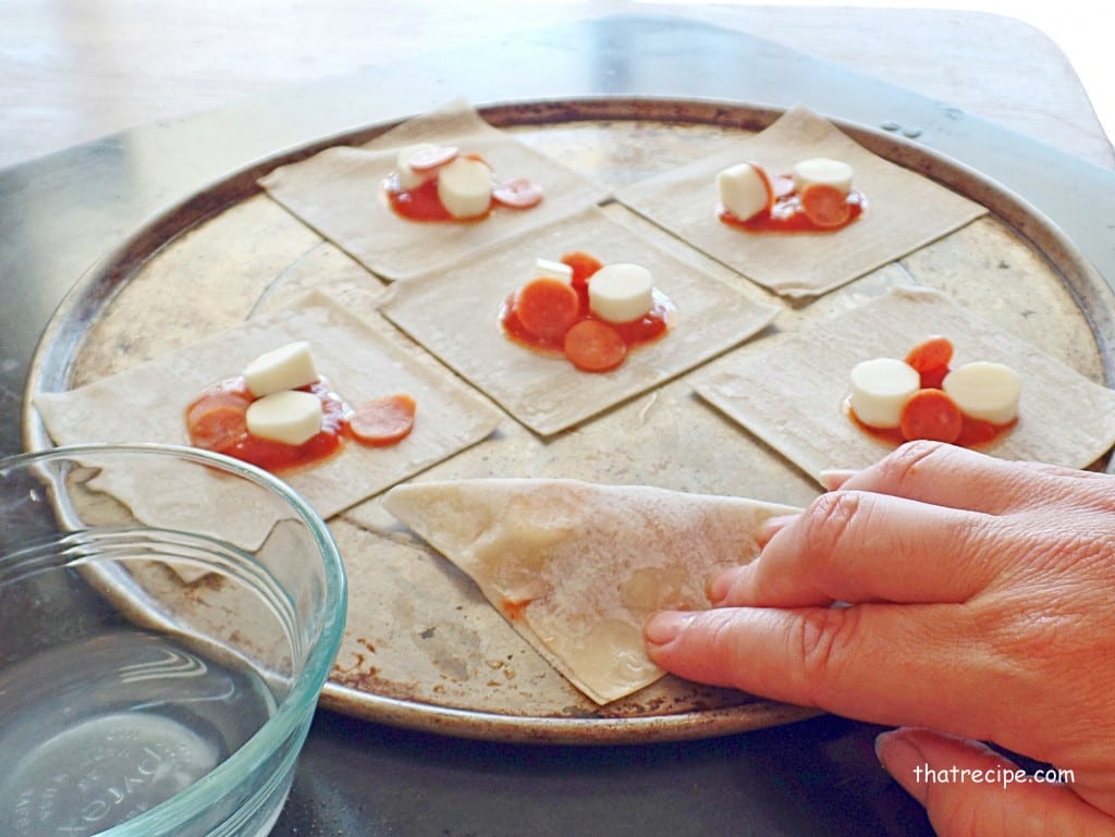 hand sealing pizza gyoza before baking