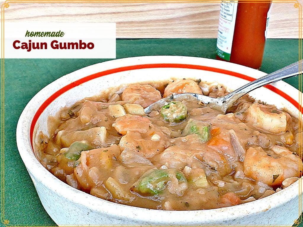 bowl of gumbo with bottle of hot sauce and text overlay "homemade cajun gumbo"