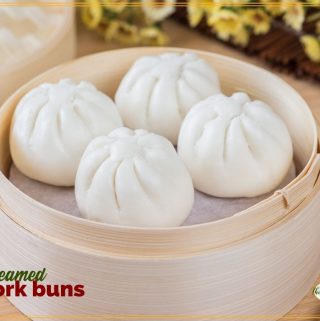 pork buns in a bamboo steamer with text overlay "steamed pork buns"