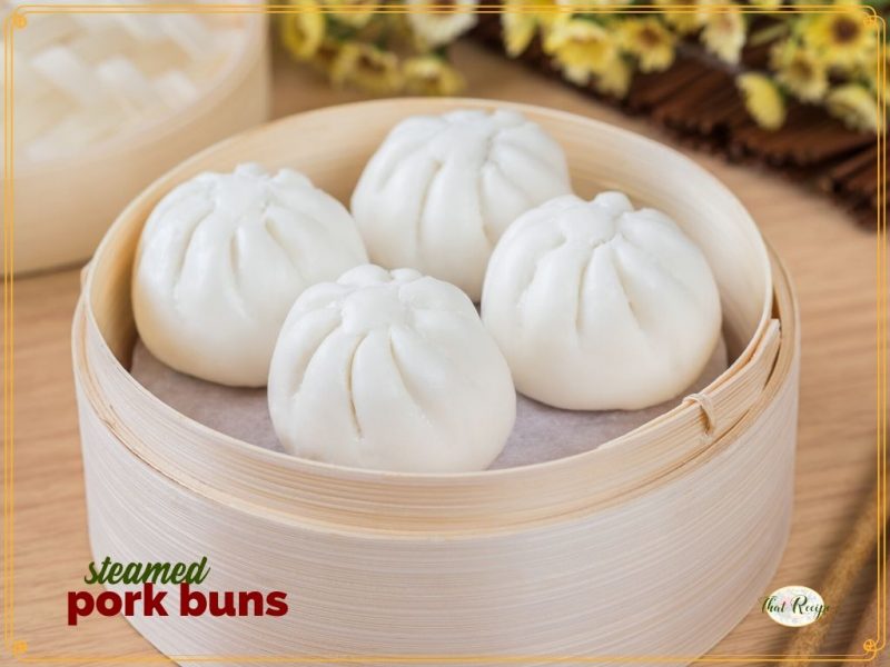 pork buns in a bamboo steamer with text overlay "steamed pork buns"