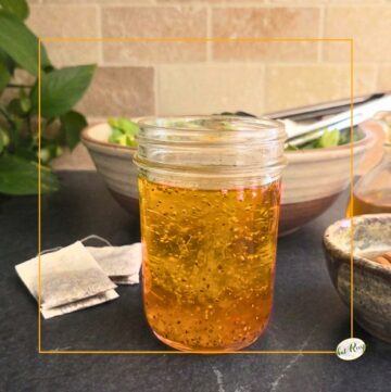 salad dressing on a counter with salad, tea bags and honey