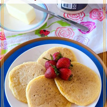 sourdough pancakes on a plate on a table with butter and syrup