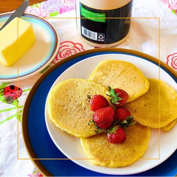 sourdough pancakes on a plate on a table with butter and syrup