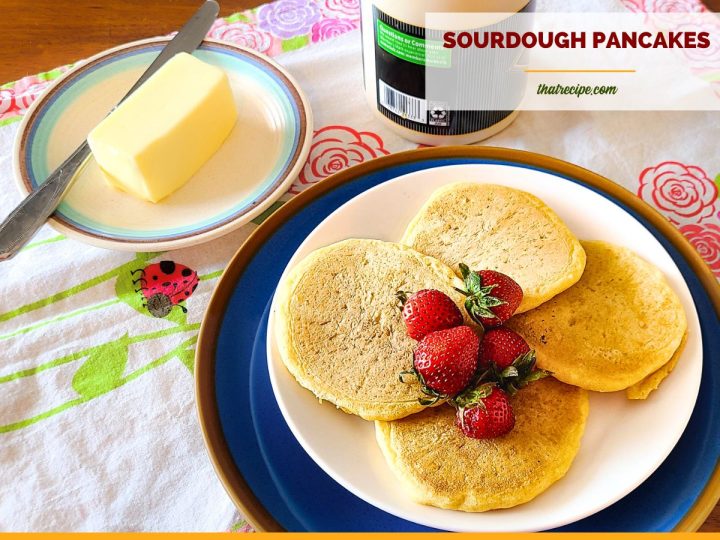 sourdough pancakes on a plate on a table with butter and syrup