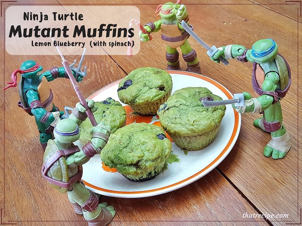 plate of green blueberry muffins with TMNT action figures around it and text overlay "Ninja Turtle Mutant Muffins Leon Blueberry (with spinach)"