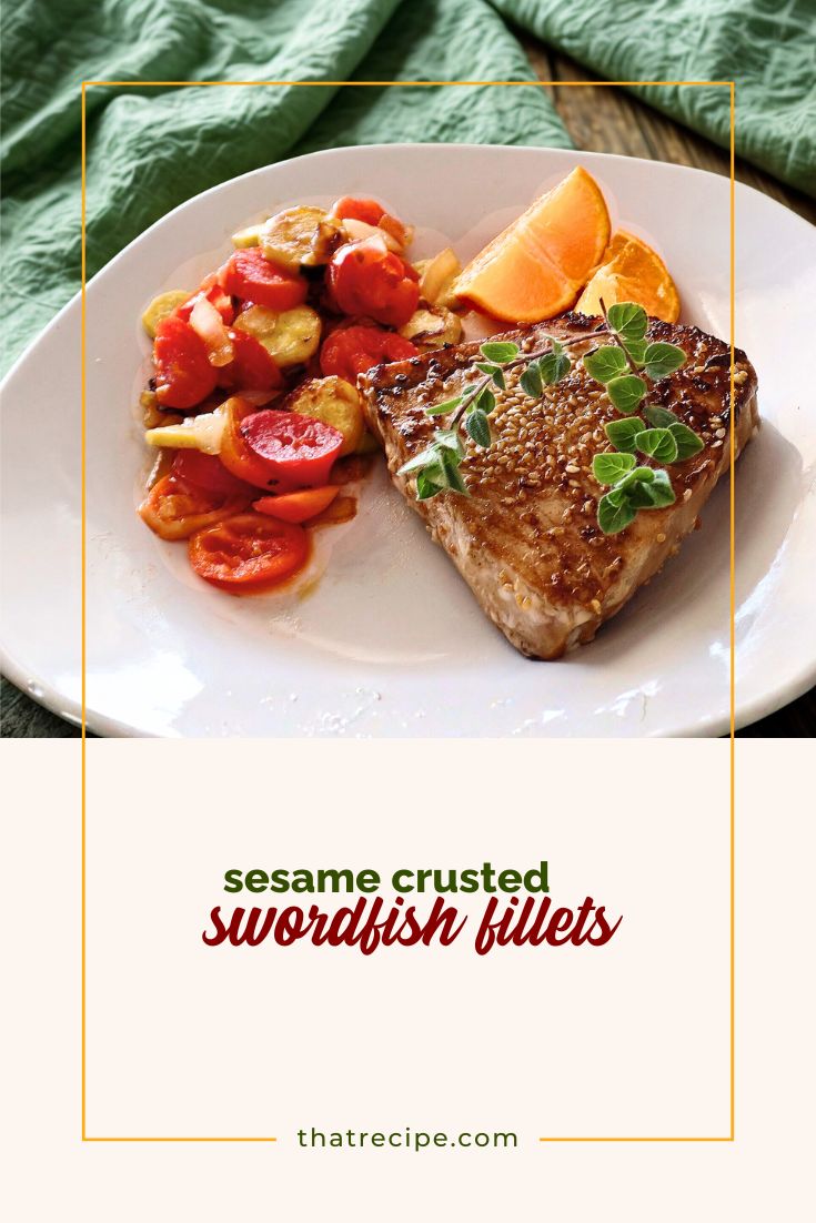 swordfish steak on a plate with vegetables and citrus fruit