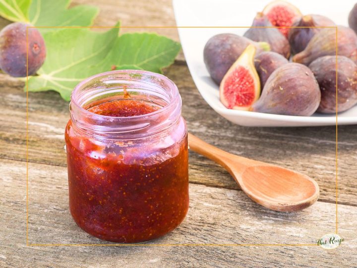 strawberry fig jam in a jar on a table with fresh figs