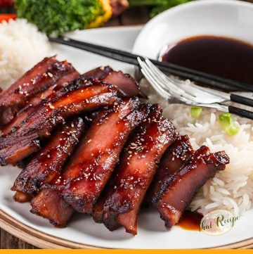 slices of chinese barbecued pork on a plate with rice.