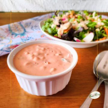 cup of thousand island dressing with a salad
