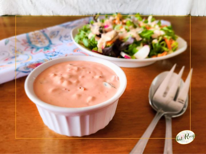 cup of thousand island dressing with a salad