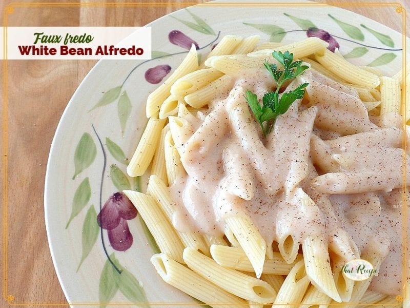 top down view of white sauce on penne noodles with text overlay Faux Fredo White Bean Alfredo"