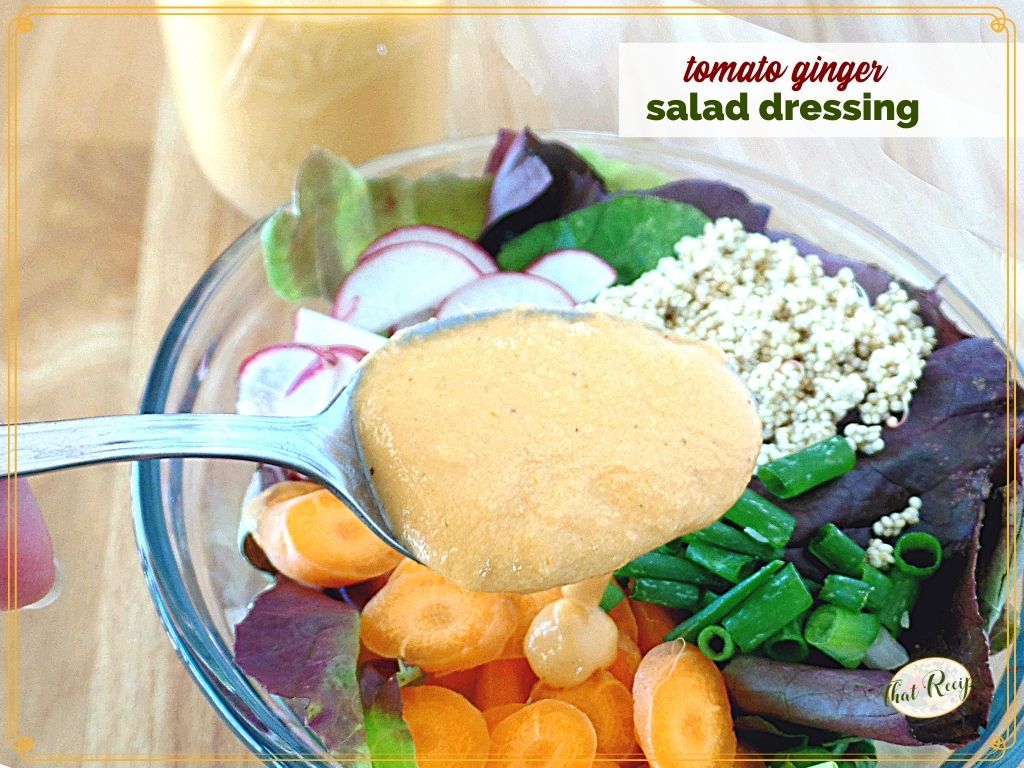 salad dressing on a spoon over a salad with text overlay "creamy tomato ginger salad dressing"