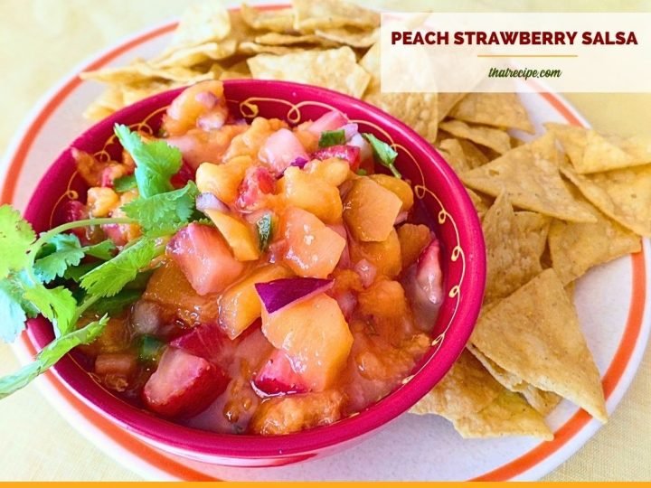 peach strawberry salsa in a bowl surrounded by chips
