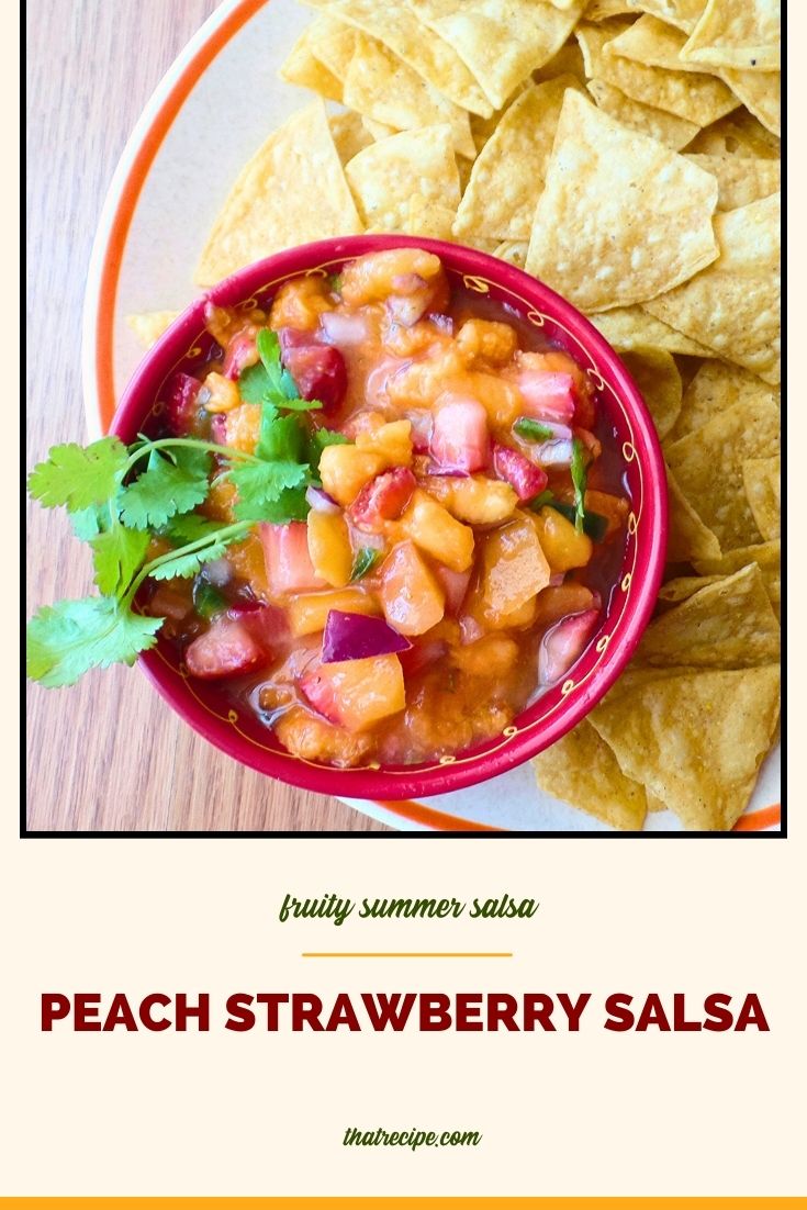 peach strawberry salsa in a bowl surrounded by chips