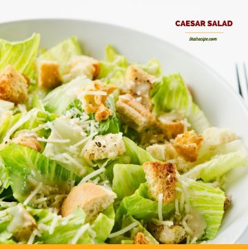 Top down view of Caesar Salad in a bowl with text overlay "Classic Caesar Salad"