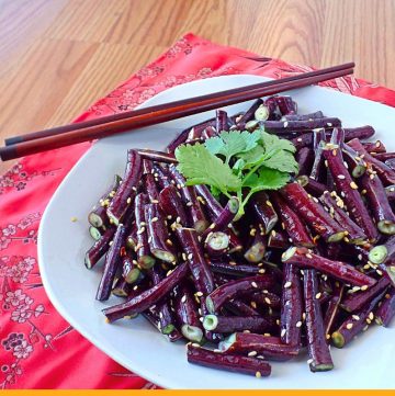 Asparagus beans on a plate with text overlay "spicy sesame yard long beans"