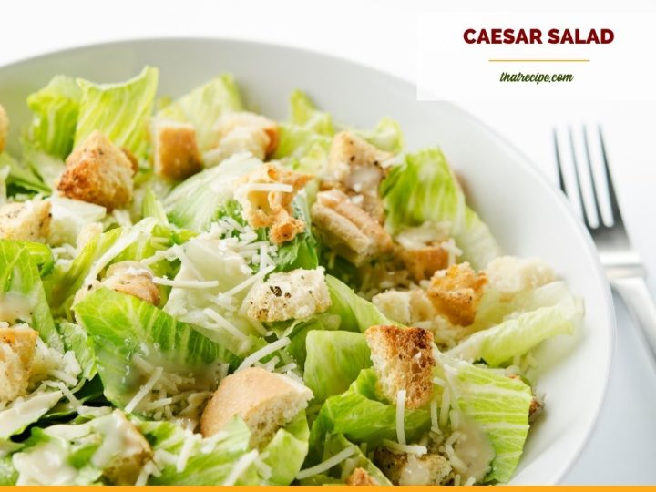 Top down view of Caesar Salad in a bowl with text overlay "Classic Caesar Salad"