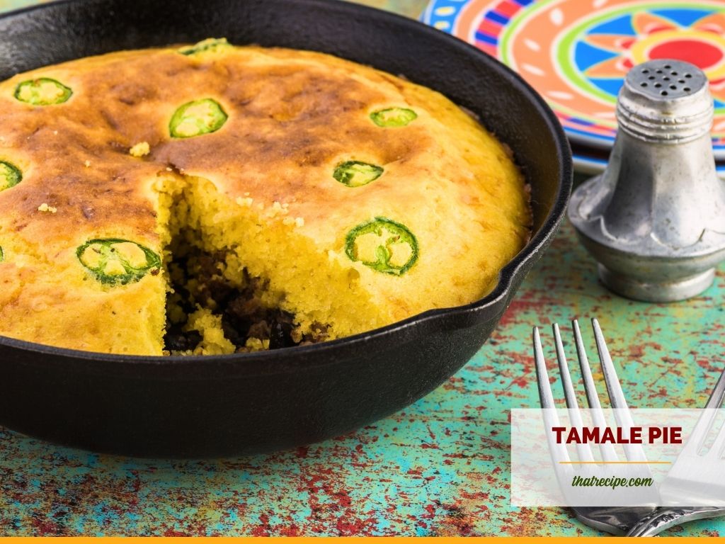 tamale pie with jalapeno pepper slices in a cast iron skillet